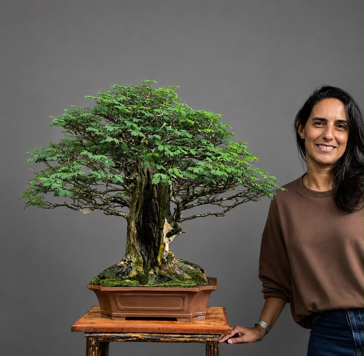 Luane Salles ao lado de um bonsai